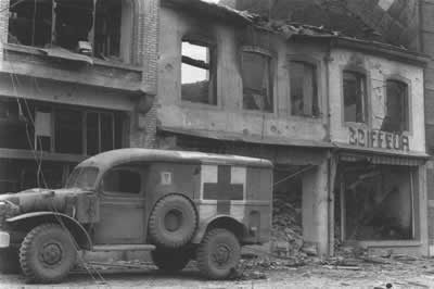 ARMY AMBULANCE IN BASTOGNE, standing ready to load casualties of the siege